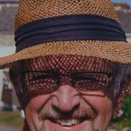Roy Winstanley in a straw hat and red spotted neckerchief, smiling to camera