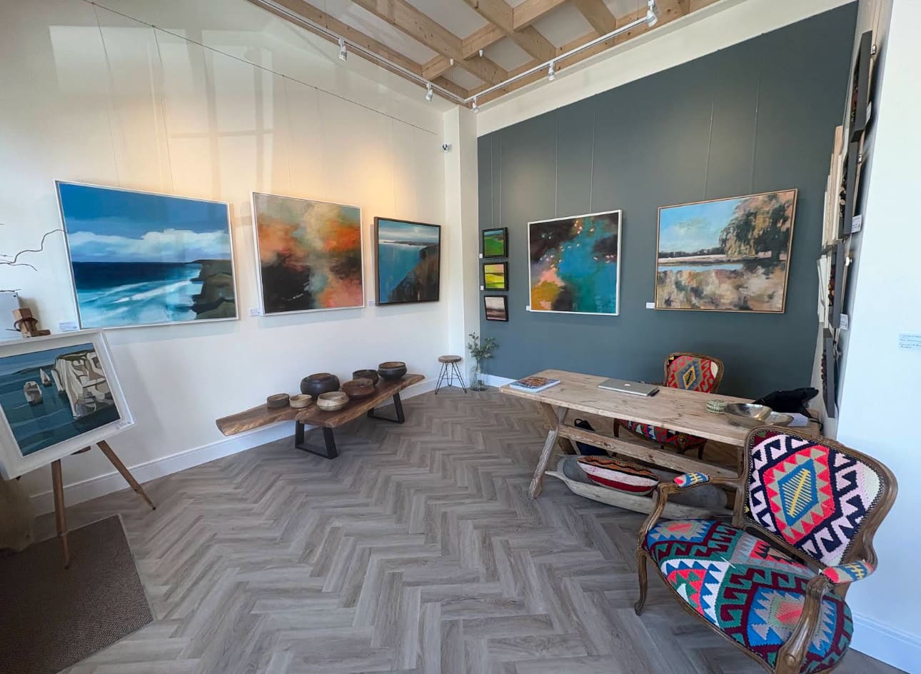 Inside The Walnut Gallery — contemporary paintings, hand-turned wooden bowls and kilim-upholstered chairs in the main gallery space