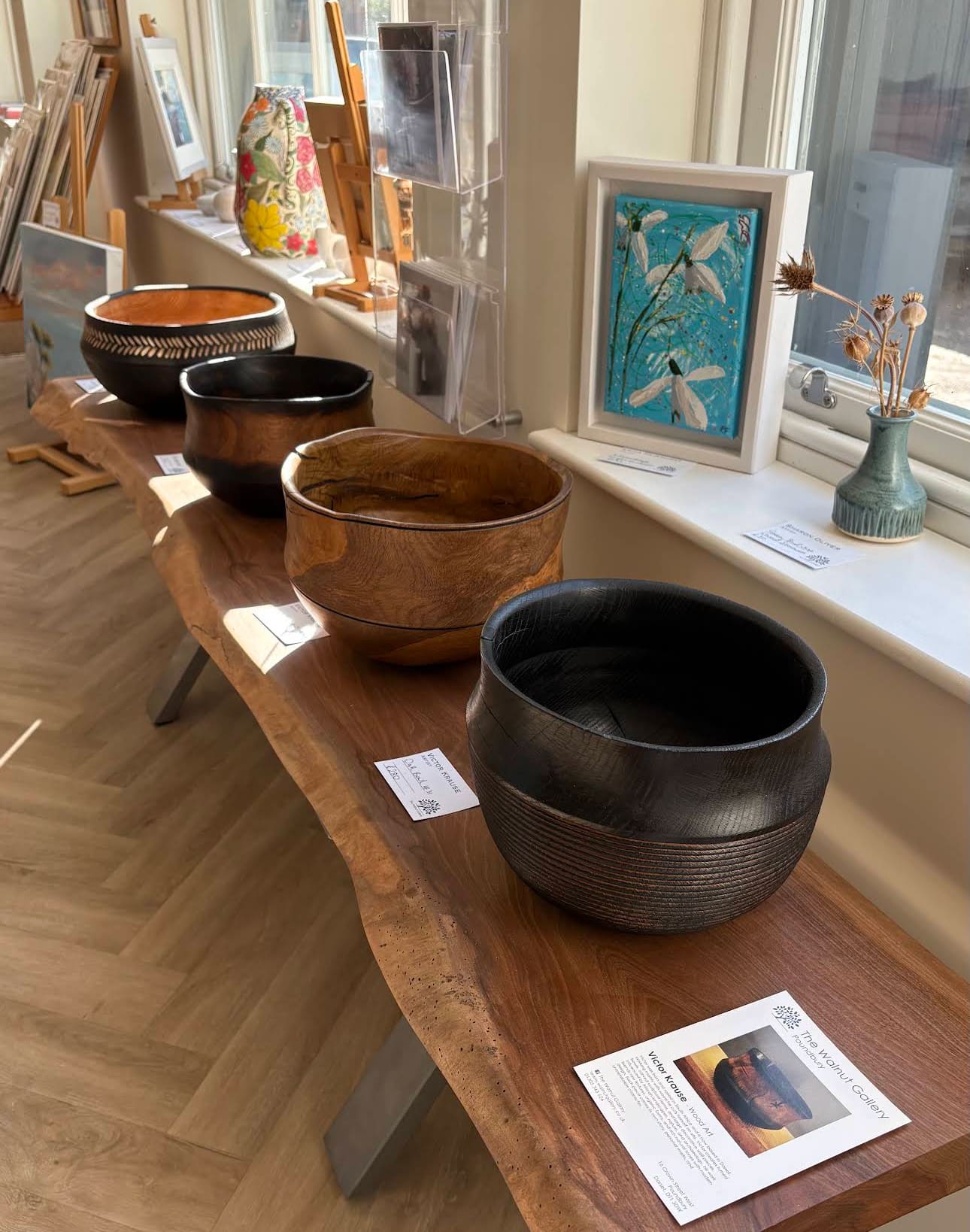 Hand-turned wooden bowls displayed on a live-edge wooden bench at The Walnut Gallery